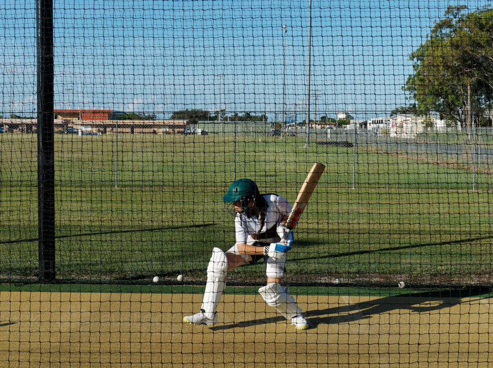 Cricket training and practice in the nets for left handed female cricket player - Australian Stock Image