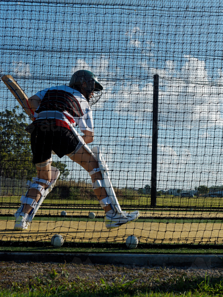 Cricket training and practice in the nets for left handed female cricket player - Australian Stock Image