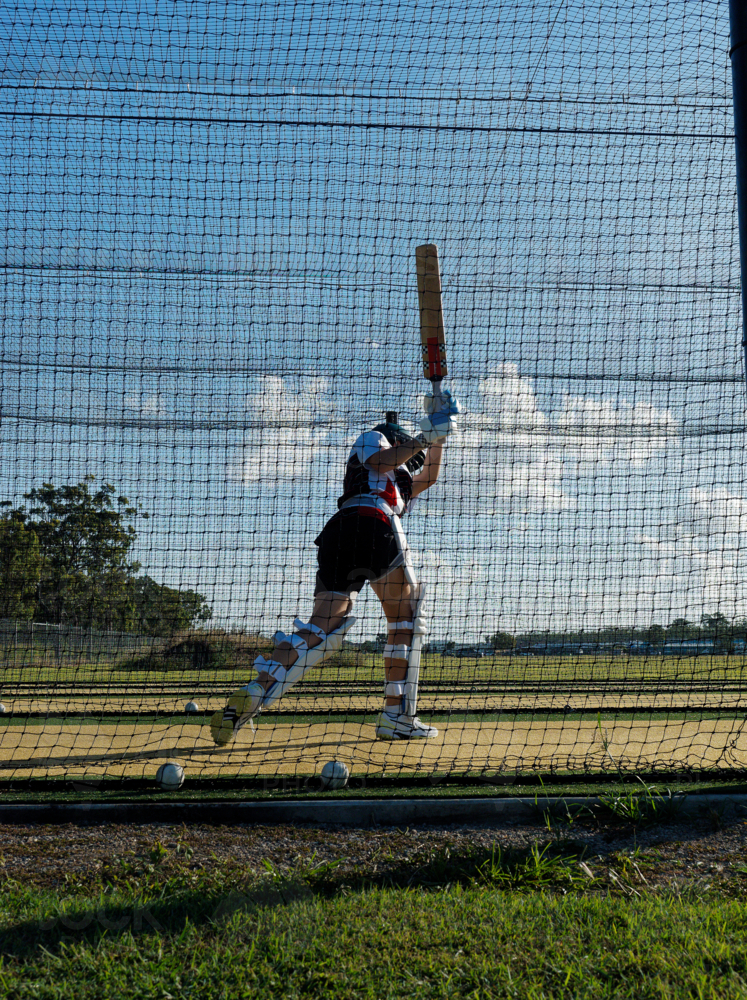 Cricket training and practice in the nets for left handed female cricket player - Australian Stock Image