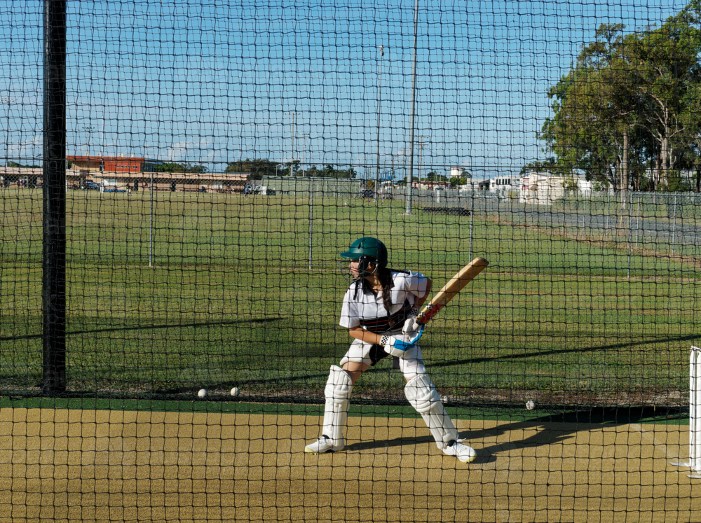 Cricket training and practice in the nets for young left handed female cricket player - Australian Stock Image