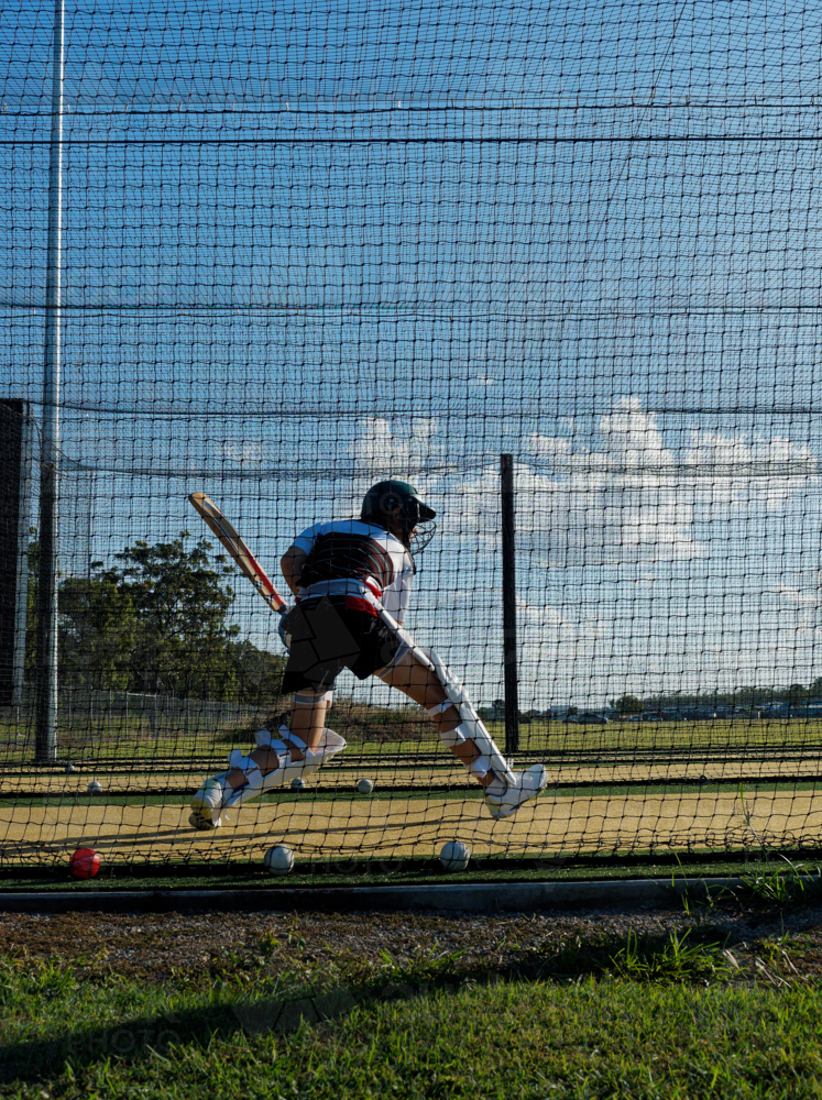 Cricket training and practice in the nets for young teen left handed female cricket player - Australian Stock Image