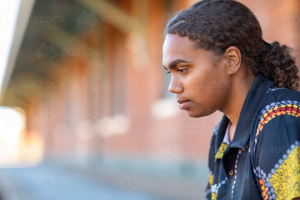 cropped head and shoulders of teen girl with hair tied back - Australian Stock Image
