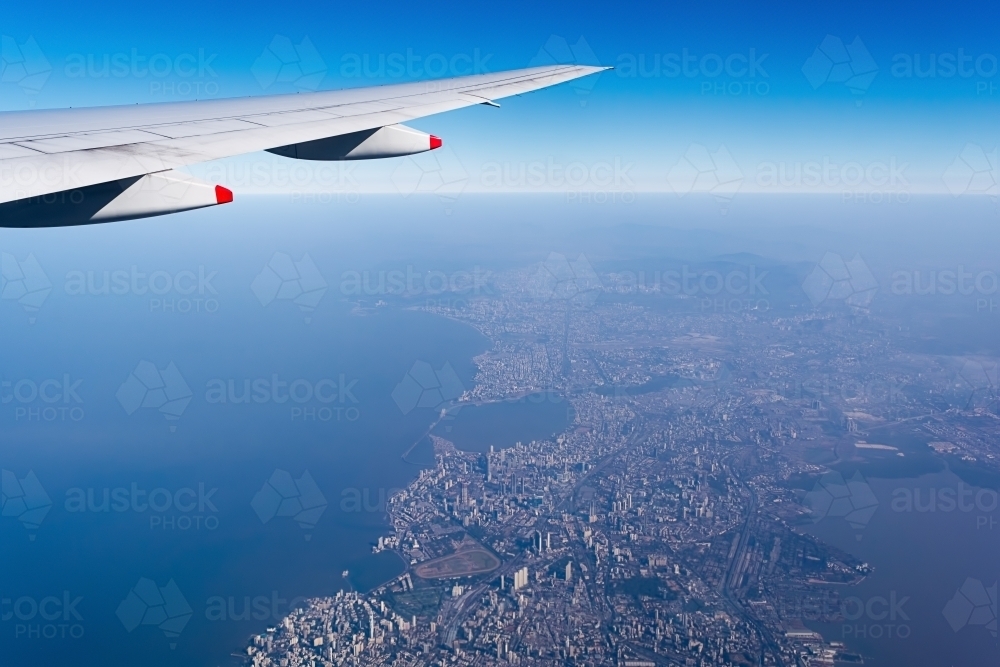 Cropped Image Of Aircraft Wing Over coastal city - Australian Stock Image