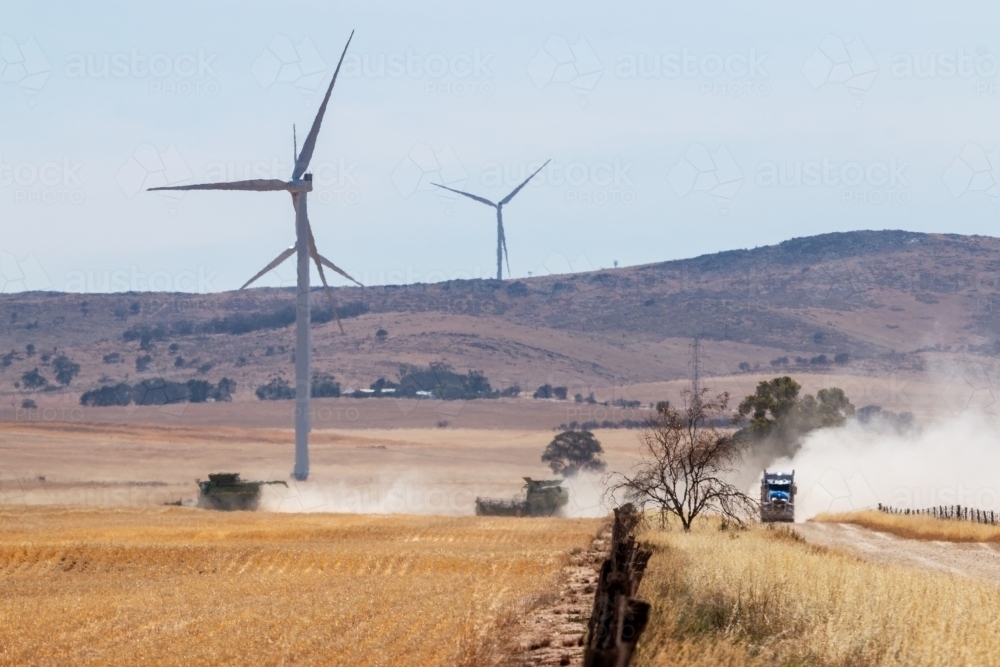 crops being harvested under wind turbines - Australian Stock Image