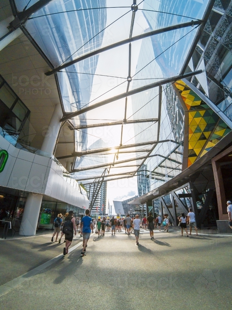 Crowds of people walking under a glass panelled arcade - Australian Stock Image