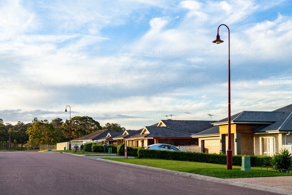 Curved light posts along neat quiet street - Australian Stock Image