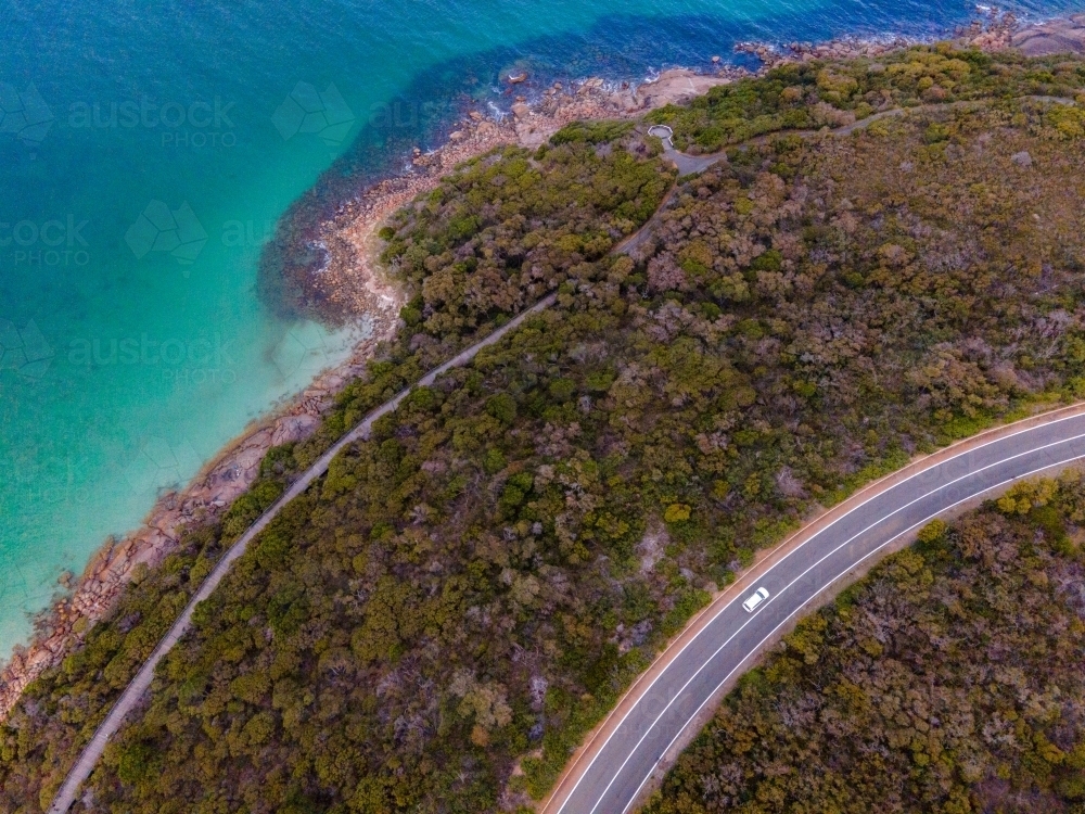 Curved road along coastline surrounded by bush scrub - Australian Stock Image