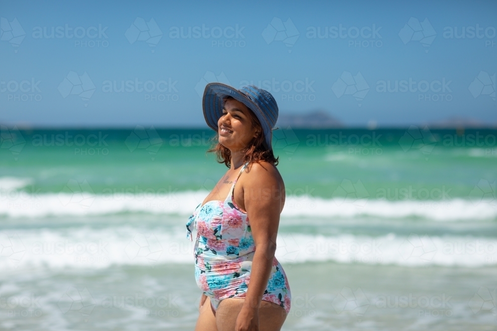 curvy dark-skinned lady in swimsuit at the beach - Australian Stock Image