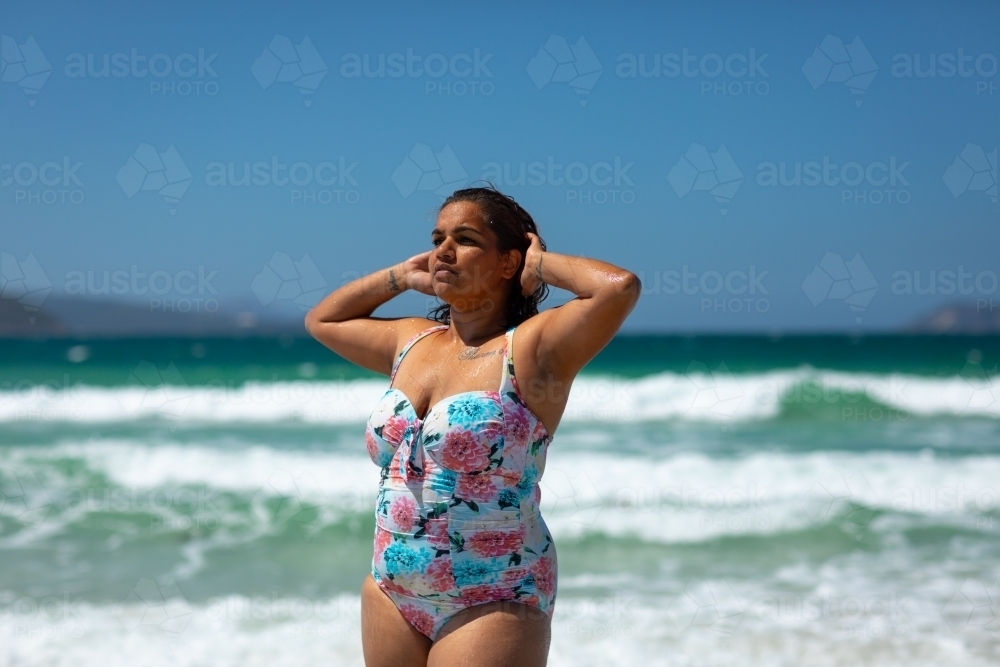 curvy model posing in swimsuit at beach - Australian Stock Image