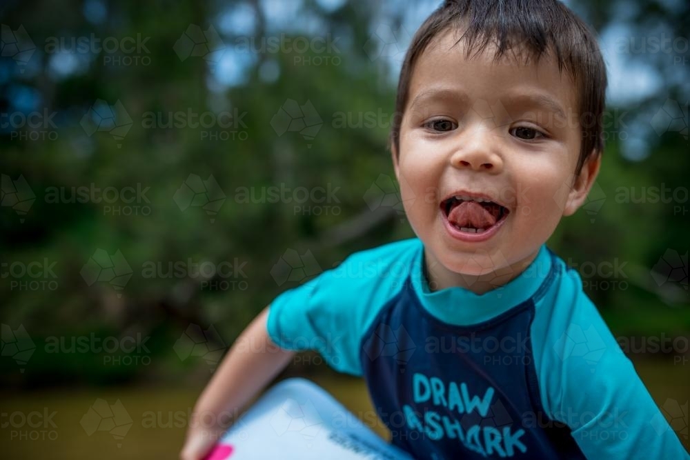 Cute 3 year old mixed race boy plays and swims in a river - Australian Stock Image