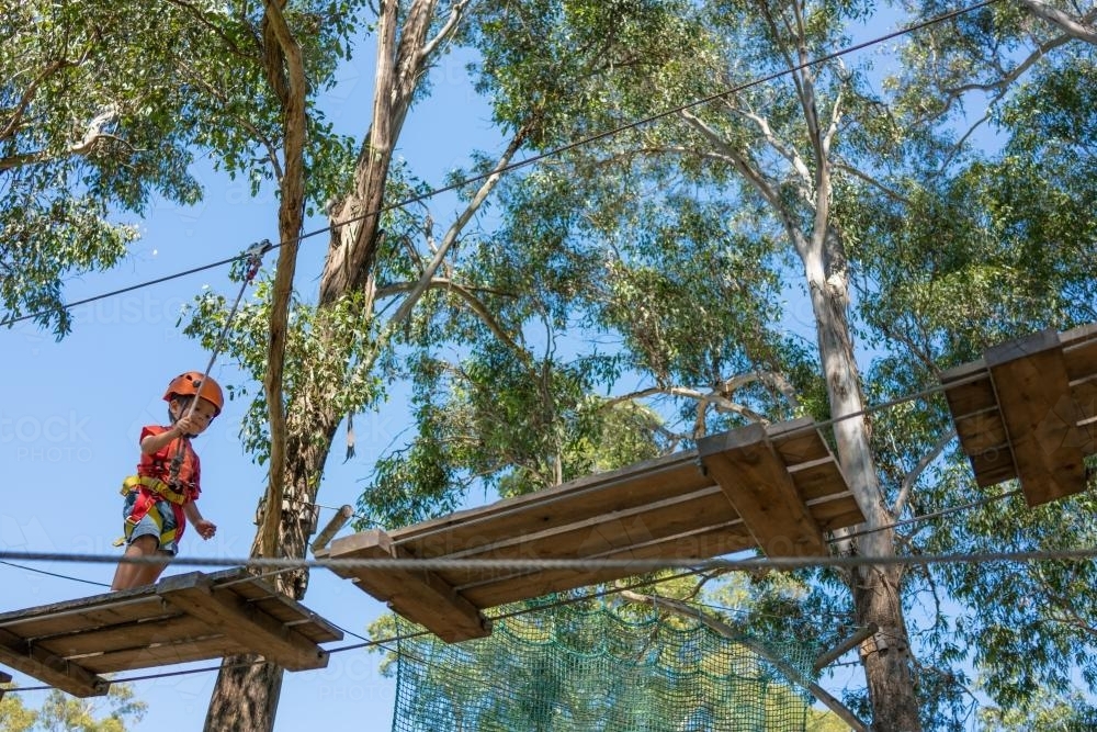 Cute 3 year old mixed race boy plays on an adventure ropes course - Australian Stock Image