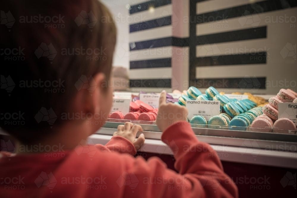 Cute 4 year old mixed race boy chooses a macaron treat - Australian Stock Image