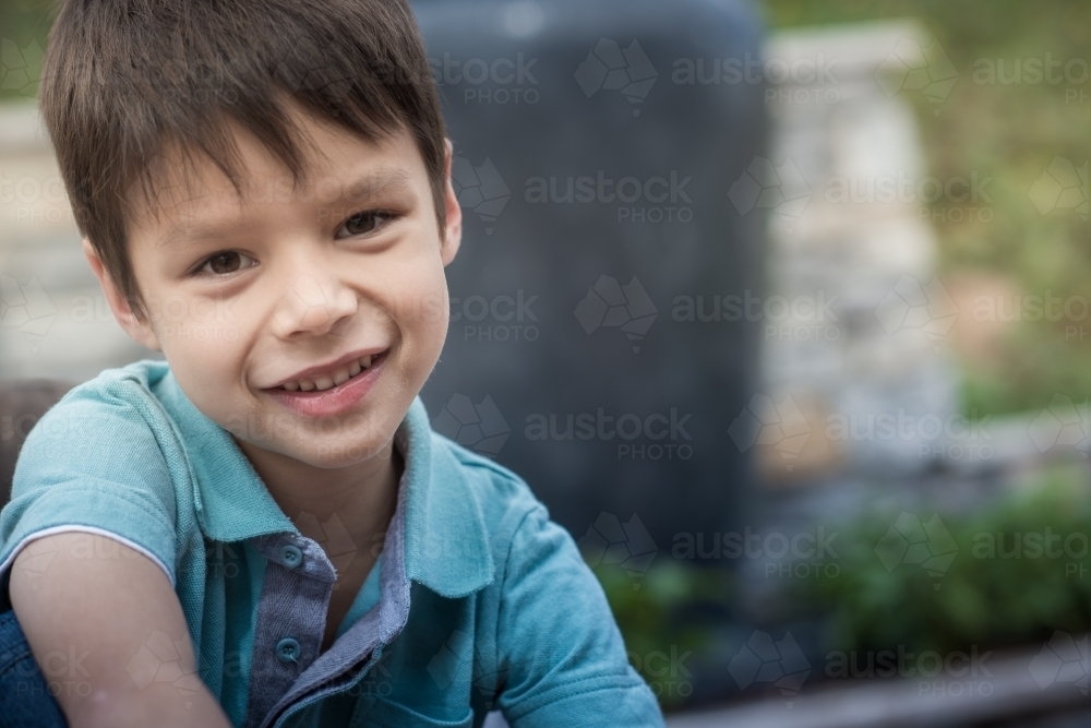 Cute 6 year old mixed race boy plays happily in his suburban backyard - Australian Stock Image