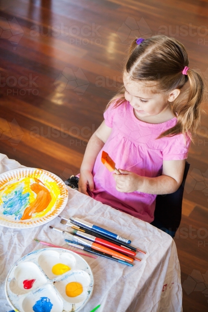 Cute child making a painted craft for schoolwork - Australian Stock Image