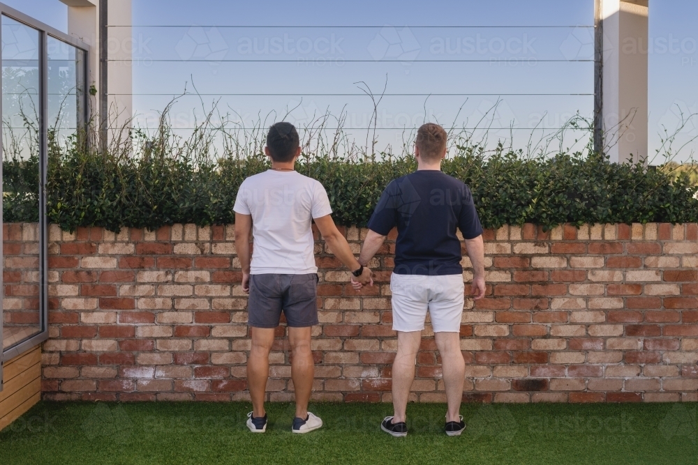 cute gay couple holding hands - Australian Stock Image