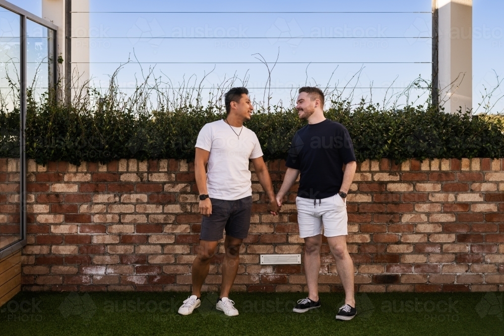 cute gay couple holding hands - Australian Stock Image