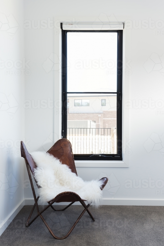 Cute leather chair with sheepskin rug throw - Australian Stock Image