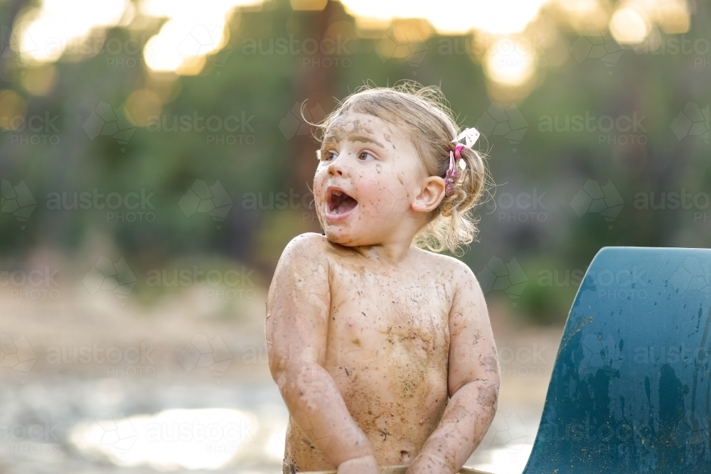 Image of Cute little girl playing in mud Austockphoto