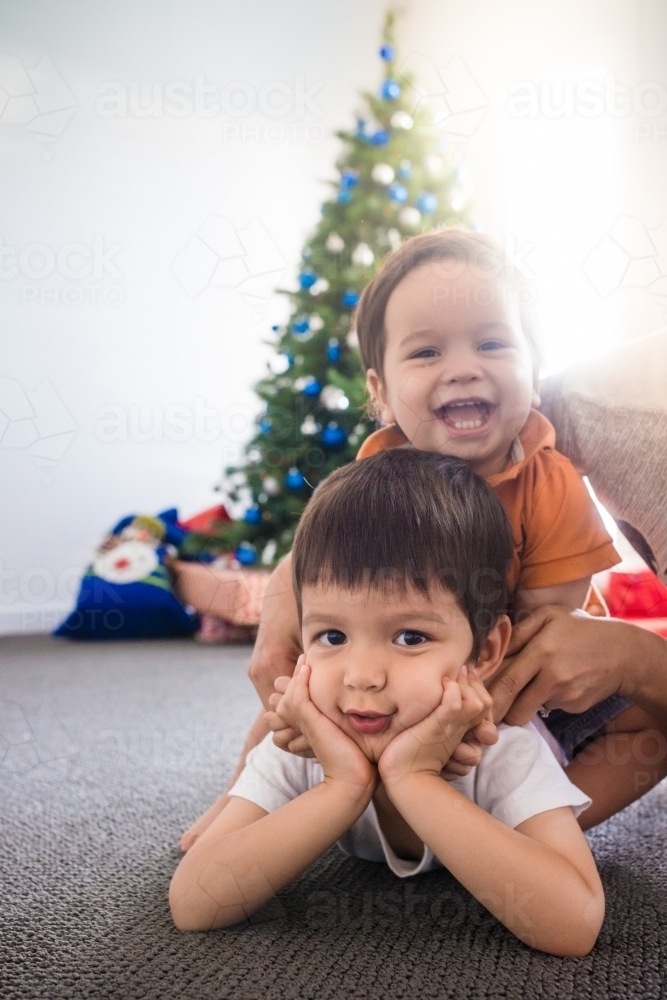 Cute mixed race 1 and 4 year old brothers waiting for Christmas - Australian Stock Image