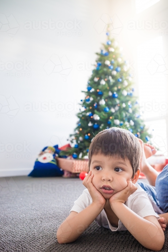 Cute mixed race 4 year old boy waiting for Christmas - Australian Stock Image