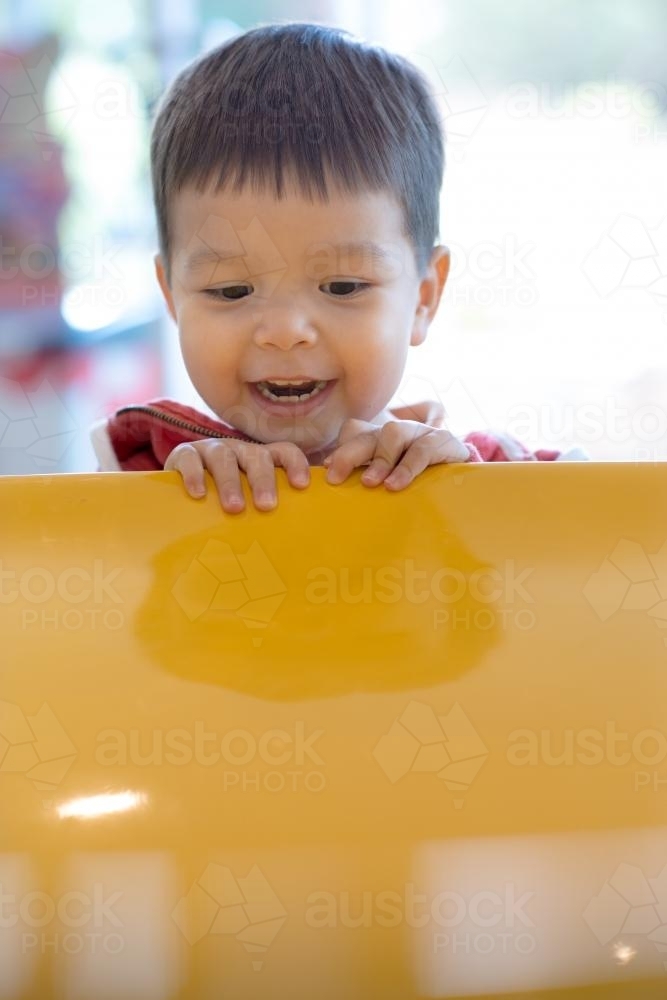 Cute mixed race boy plays with a charity donation coin vortex - Australian Stock Image