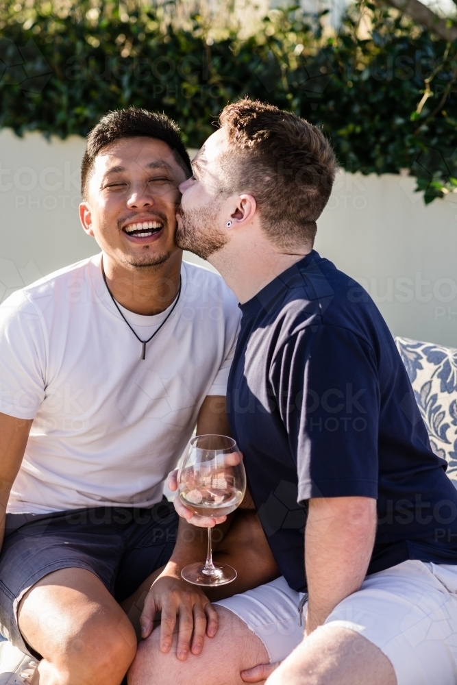 Cute moment as a man kisses his boyfriend - Australian Stock Image
