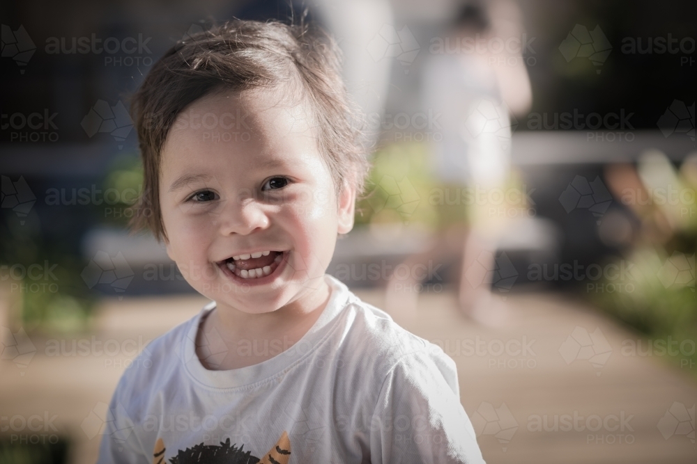 Cute one year old boy outside in his suburban backyard - Australian Stock Image