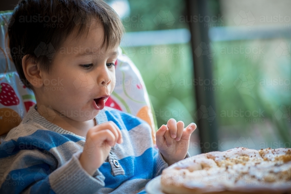 Cute two year old boy gets excited about a healthy pizza - Australian Stock Image