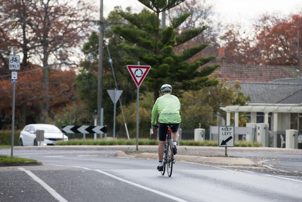 cyclist approaching a roundabout in the city - Australian Stock Image