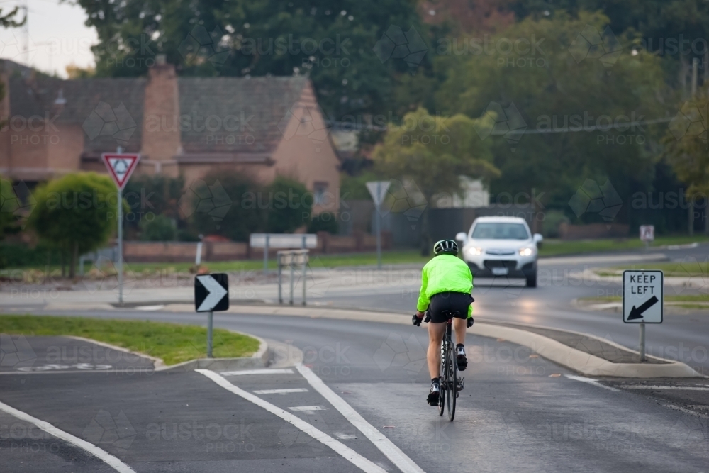 Cyclist approaching a roundabout in the evening - Australian Stock Image