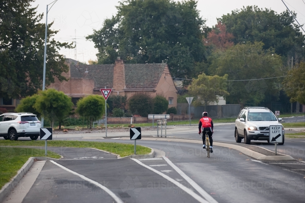 cyclist approaching a roundabout in the evening - Australian Stock Image