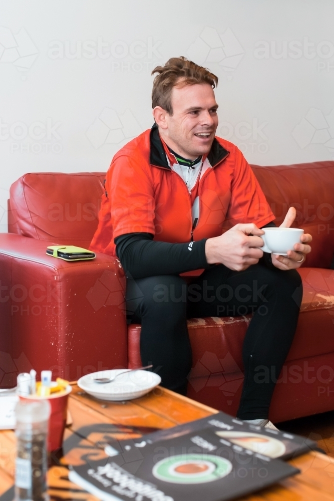 Cyclist enjoying a coffee after a morning ride - Australian Stock Image