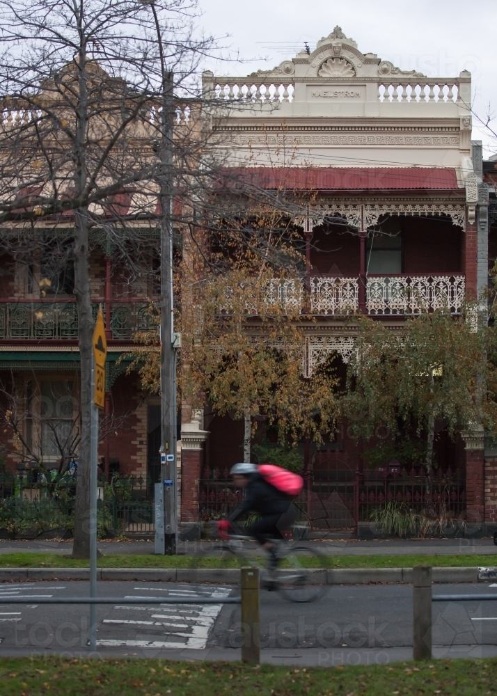cyclist riding down a street in inner city suburbs - Australian Stock Image