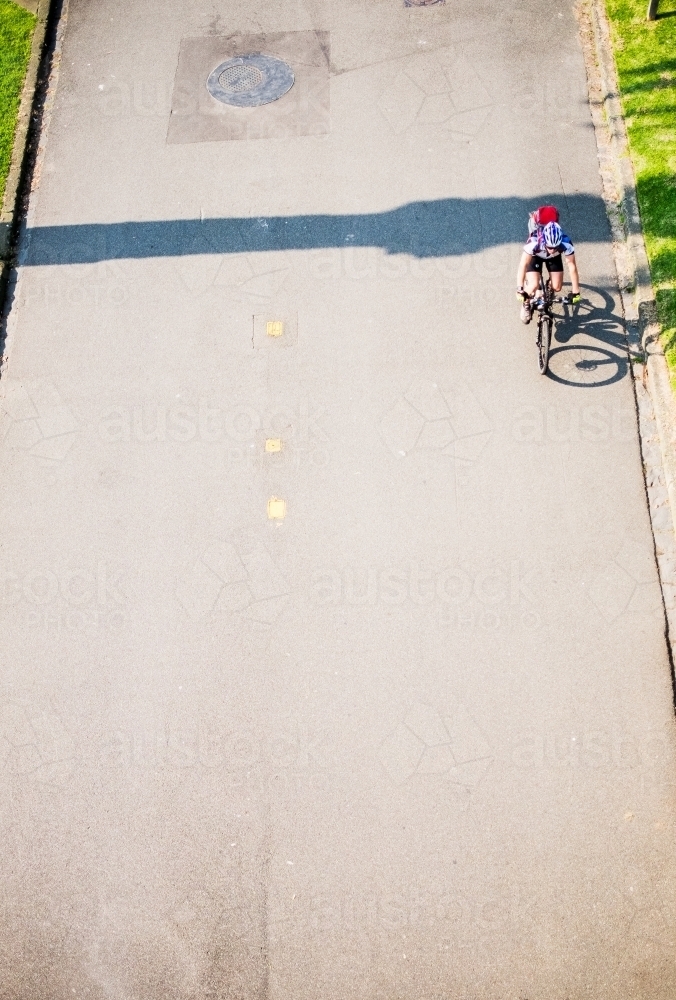Cyclist riding on city pathway from above - Australian Stock Image