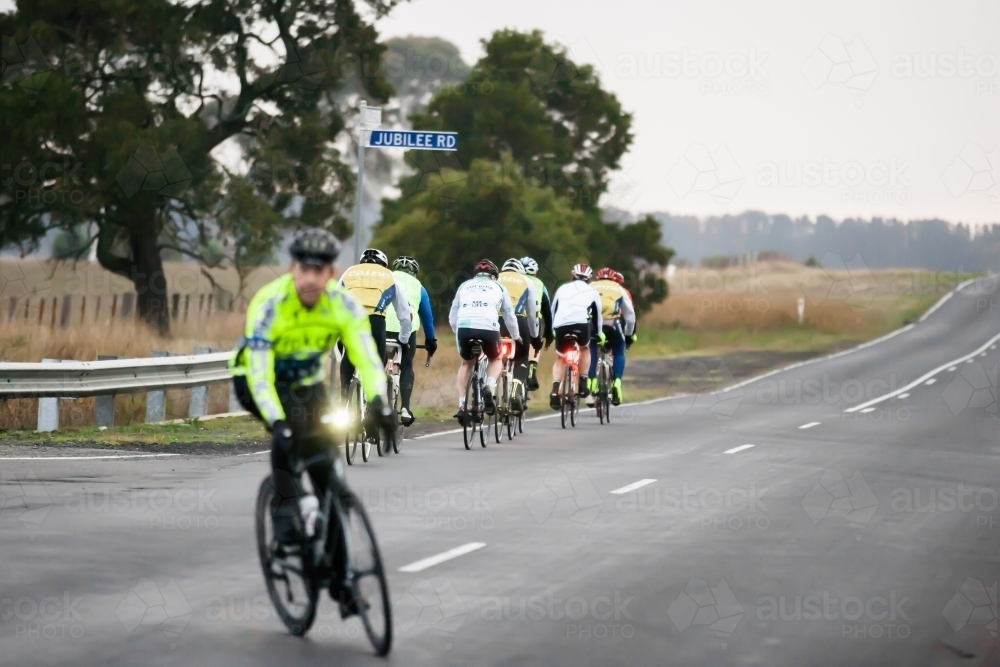 Cyclist turing at intersection after another group has passed - Australian Stock Image