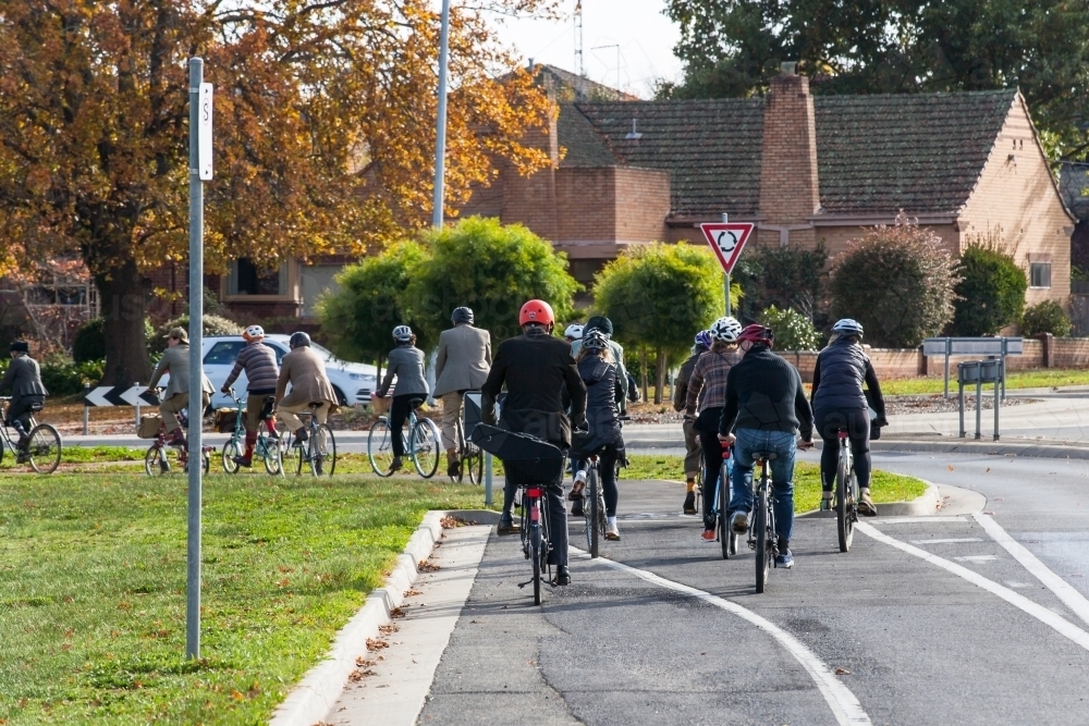 Cyclists on a Tweed Ride approaching a roundabout in a city - Australian Stock Image