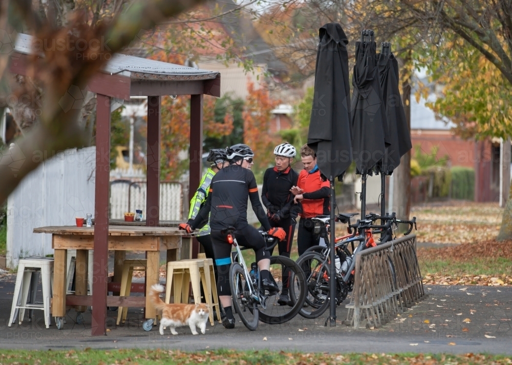 Cyclists talking at a cafe after a morning ride - Australian Stock Image