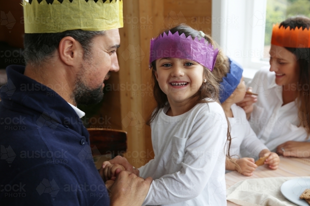 Dad and daughter smiling wearing Christmas hats - Australian Stock Image