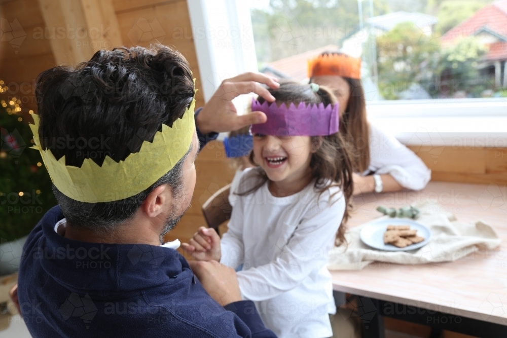 Dad with daughter laughing wearing Christmas hats - Australian Stock Image