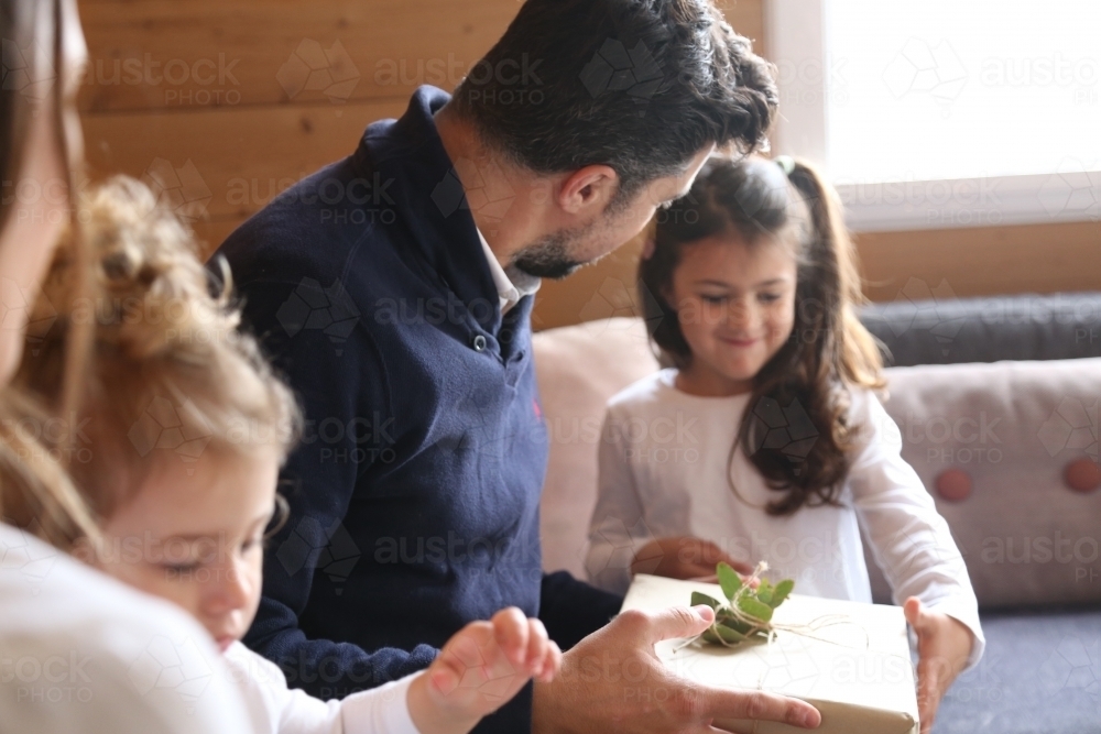 Dad with daughters and Christmas present - Australian Stock Image
