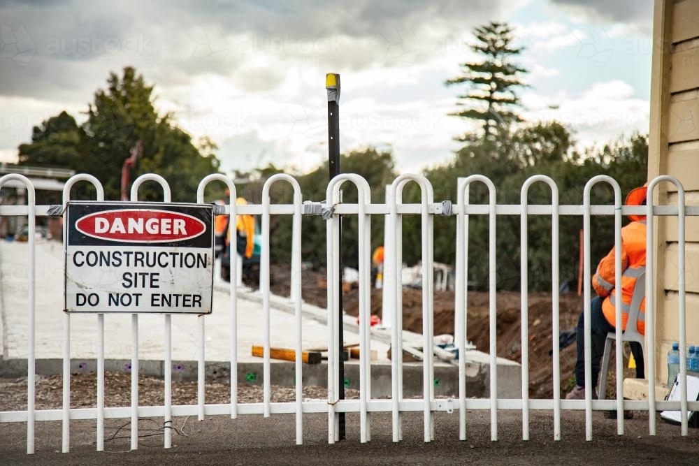 Danger construction site do not enter sign on a fence with construction site behind - Australian Stock Image