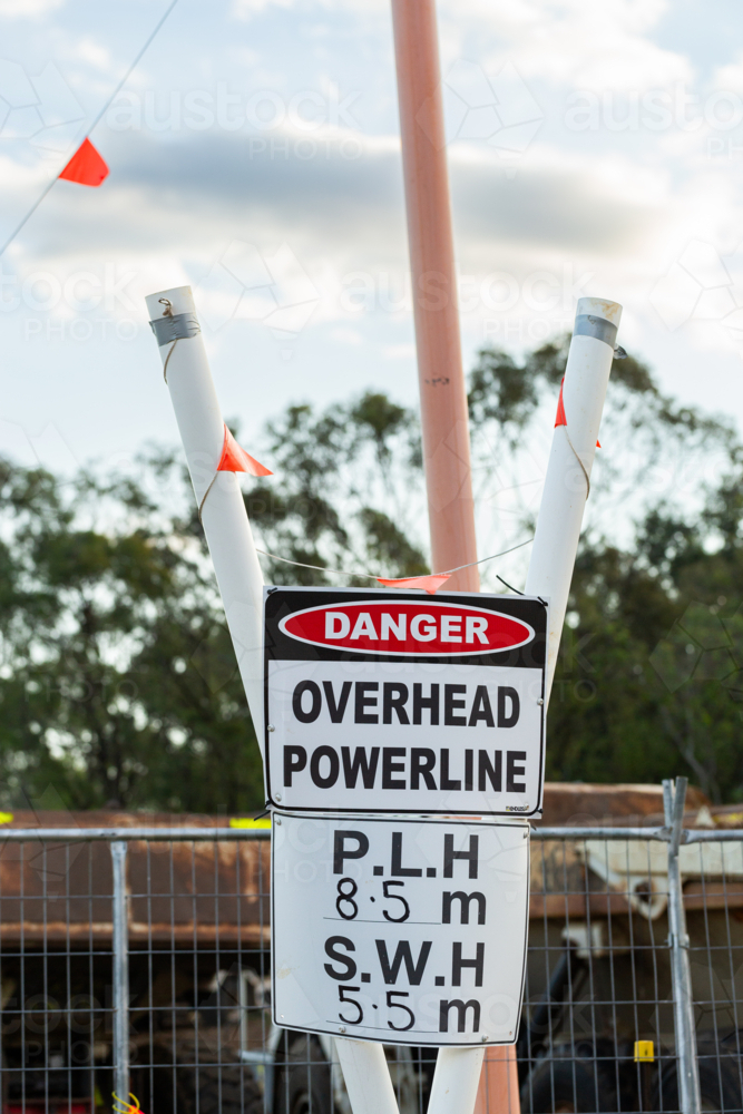Danger overhead powerline warning sign on construction worksite - Australian Stock Image