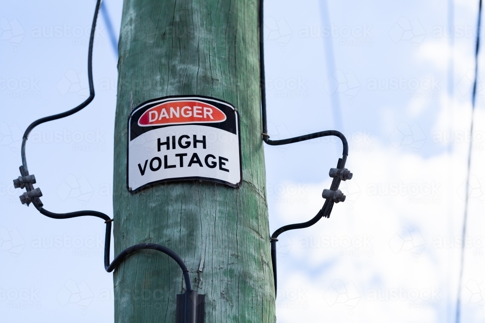 Danger warning high voltage sign on power pole - Australian Stock Image