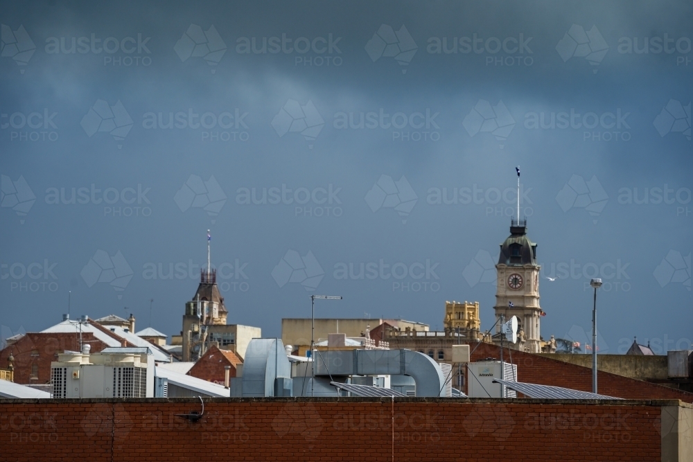 Dark clouds over city roof tops and historic towers - Australian Stock Image