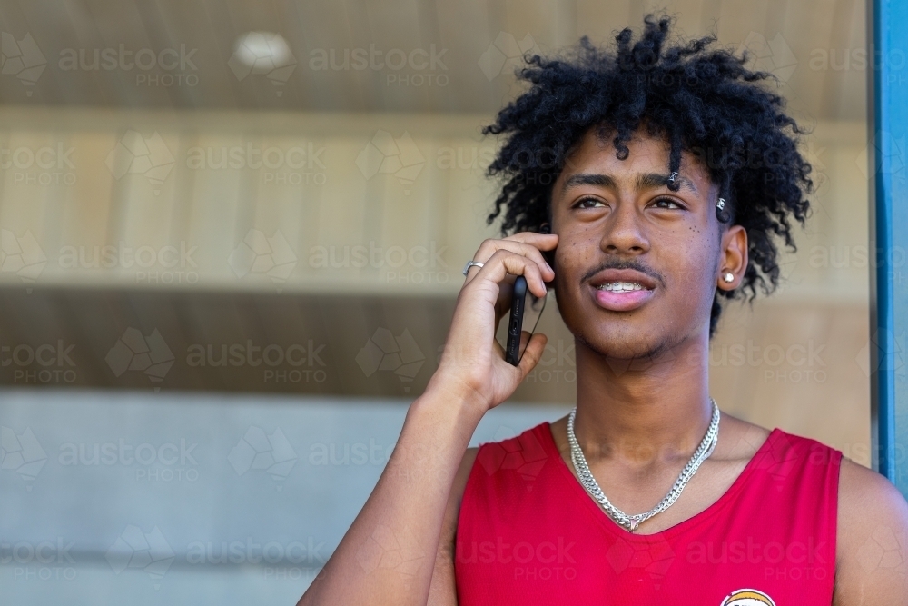 dark-haired teen boy with mobile phone - Australian Stock Image