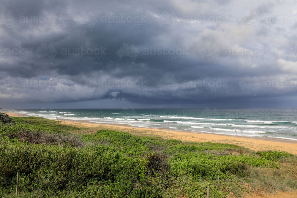Dark stormy clouds forming over North Beach in Mylestom, NSW, Australia. Dramatic coastline - Australian Stock Image