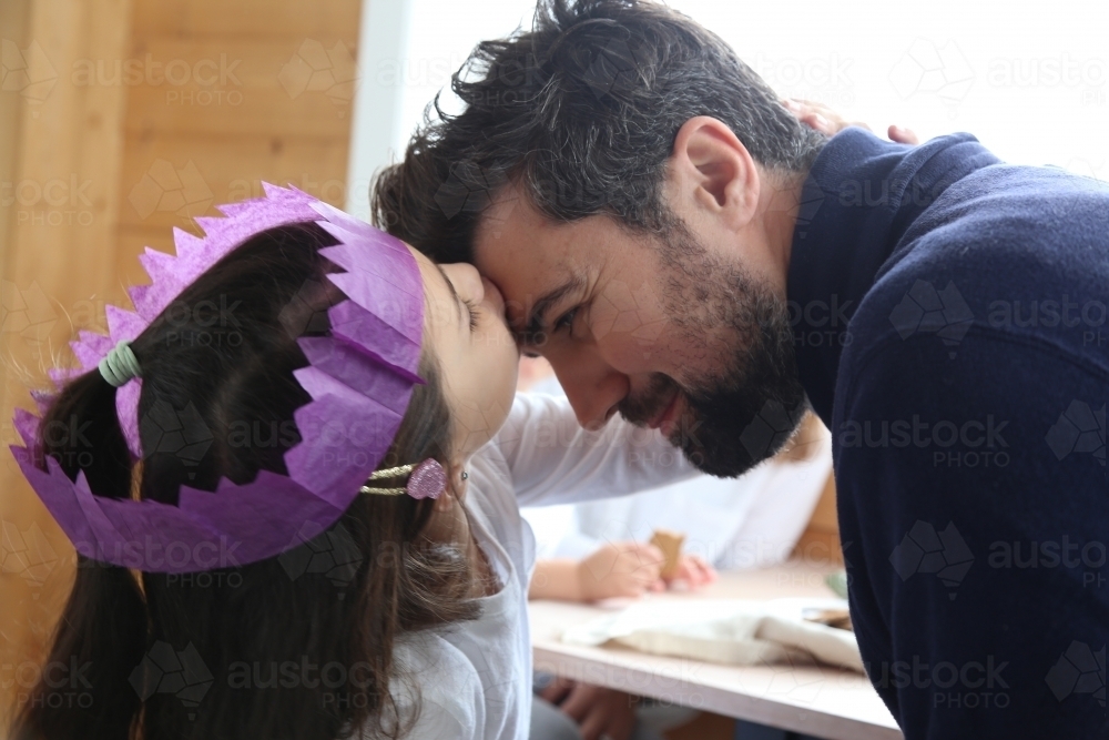 Daughter kissing dad wearing Christmas hat : Austockphoto Daughter kissing dad wearing Christmas hat - Australian Stock Image