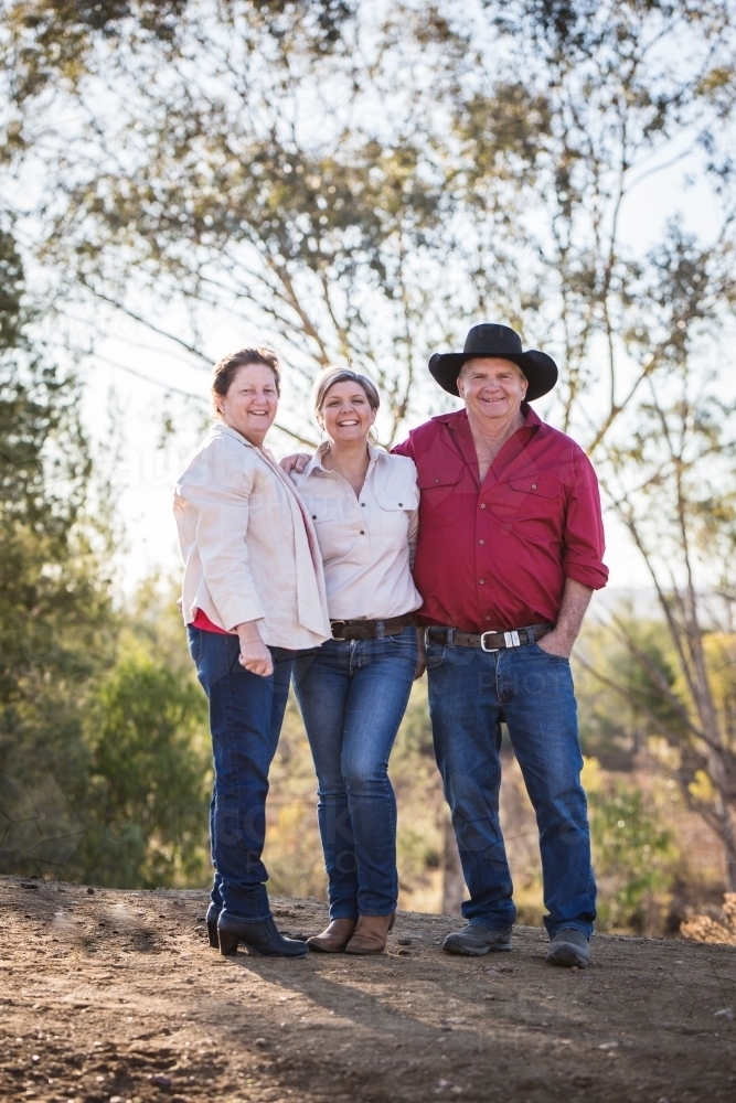 Daughter standing with father and step mother on family farm in drought - Australian Stock Image