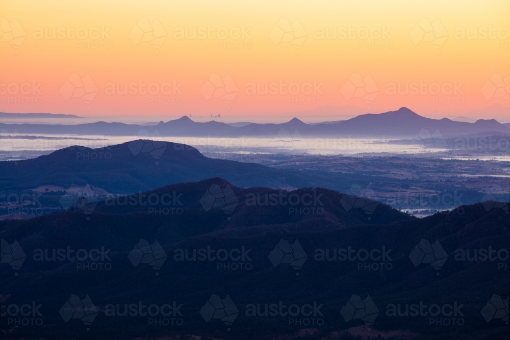 Dawn across the Scenic Rim looking towards a distant Brisbane. - Australian Stock Image