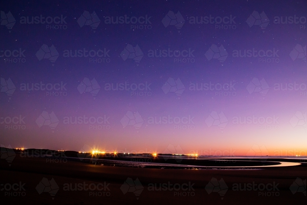 Dawn over beach at low tide - Australian Stock Image